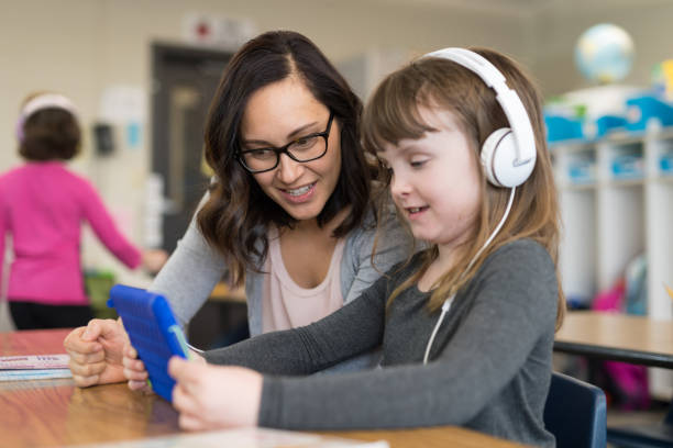 istock Teacher helping a first grader in her classroom 1165215323