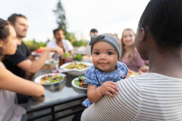 um grupo de amigos adultos novos que jantam o fresco do al em um pátio - asian ethnicity baby mother family - fotografias e filmes do acervo