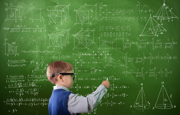 istock Little boy writing on green blackboard 1165219565