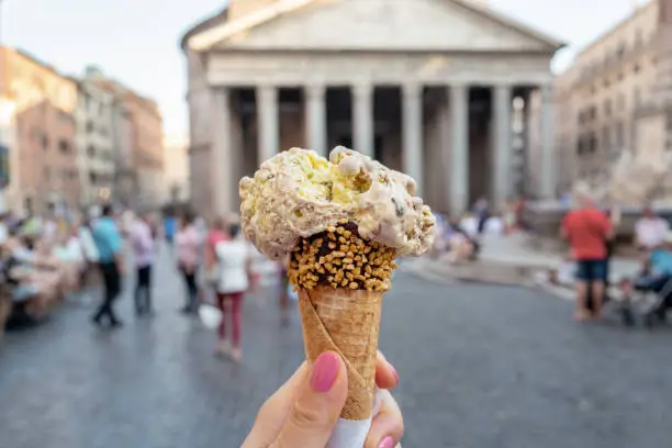 Close-up of woman olding authentic Italian gelato in front of the pantheon in Rome, Italy.
