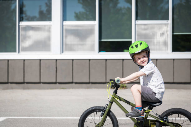 istock Little Redhead Boy Riding his Bicycle in Schoolyard 1165223151
