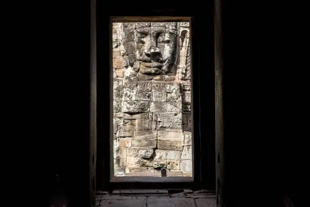 Photo of The mystery face tower in Bayon temple the state temple of the Mahayana Buddhist King Jayavarman VII in Siem Reap, Cambodia view from the inside of Bayon sanctuary.