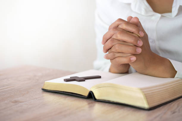 istock Hands praying on a Holy Bible, spirtuality and religion, Religious concepts 1165226951