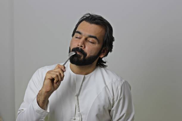 istock Arab Man Eating With Spoon Enjoying The Taste With Closed Eyes ( Yummy Tasty Delecious ) 1165227033