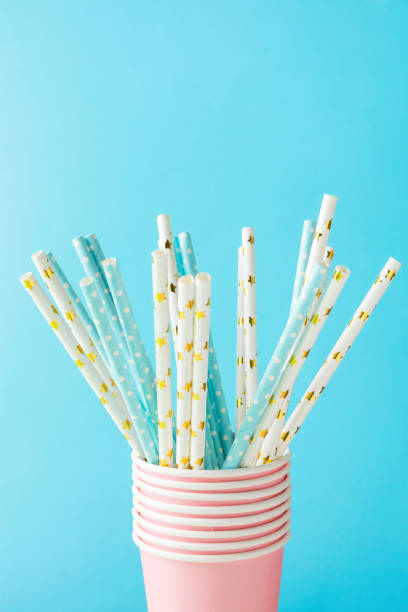 istock White and blue paper drinking straws with golden star polka dot pattern in stacked cups on blue. Zero waste nature friendly biodegradable materials. Birthday party holiday celebration background 1165228430