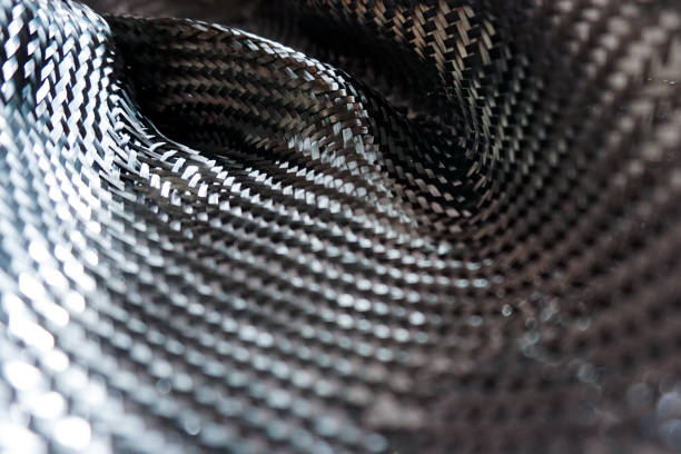 Carbon Fiber Detail Close-up detail of carbon fiber weave reflecting light carbon fibre photos stock pictures, royalty-free photos & images