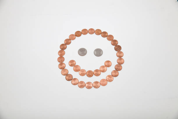Smiley face made out of coins isolated on white