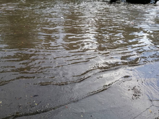 istock Large rain puddle on city street. 1165239710
