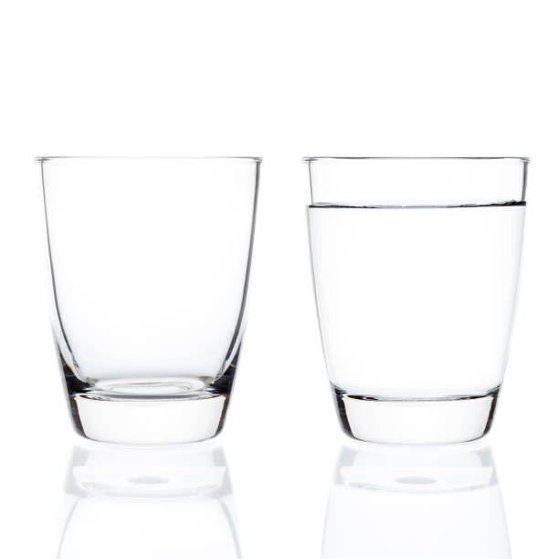 istock Empty and full water glasses isolated on white background. 1165239846