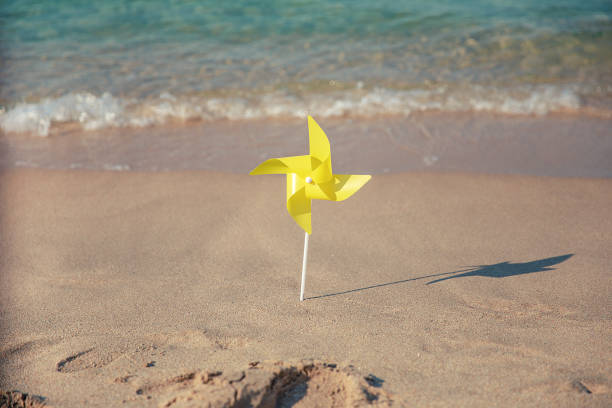 istock Pinwheels On The Beach Blowing Sunshine Concept 1165240717