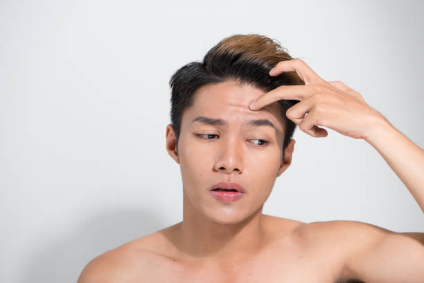 istock Handsome Asian man touching his hair close up portrait studio on white background 1165242574