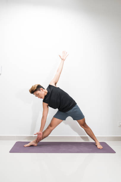 istock A man doing yoga exercises. Studio shot over white background. 1165242781