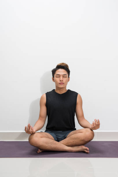 istock Young black man practicing yoga lesson with instructor, sitting in Sukhasana exercise 1165242864