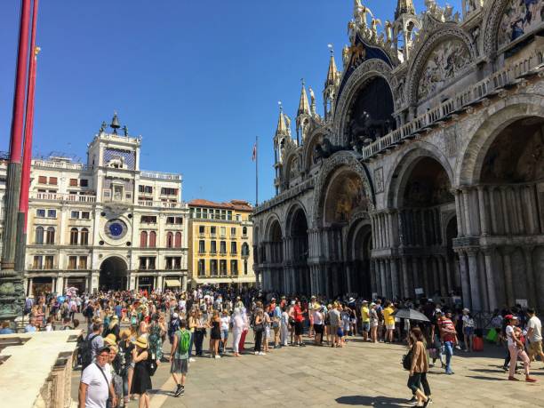 un grand groupe de touristes à l'extérieur de la basilique saint-marc sur la place saint-marc prendre des photos et profiter des sites - st marks cathedral photos et images de collection