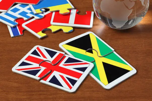 puzzle with the national flag of England and Jamaica on wooden table