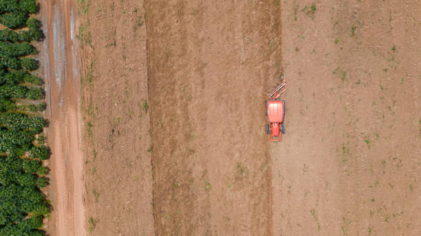 istock Top view of agricultural tractor vehicles working at field 1165250607