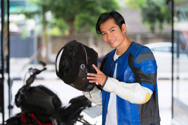 Handsome man carrying a motorcycle helmet stock photo