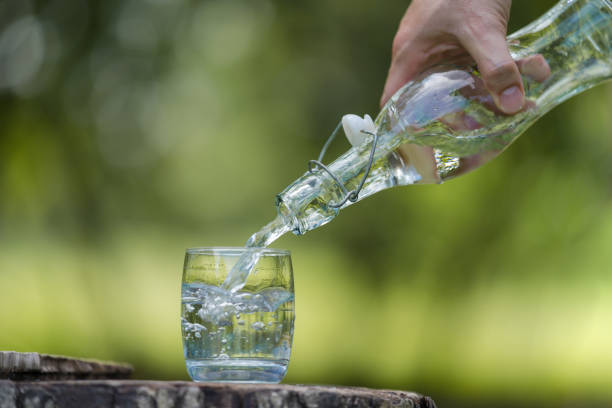 istock Hand pouring drink water from bottle into glass 1165253355