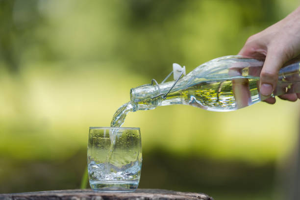 istock Hand pouring drink water from bottle into glass 1165253366