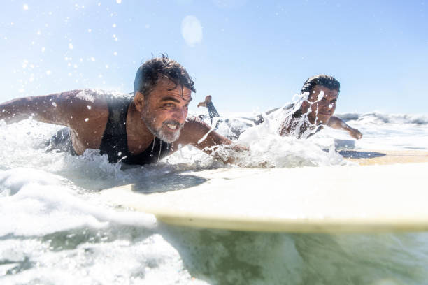 padre e hijo surfean en la playa en california - surfing beach family father fotografías e imágenes de stock