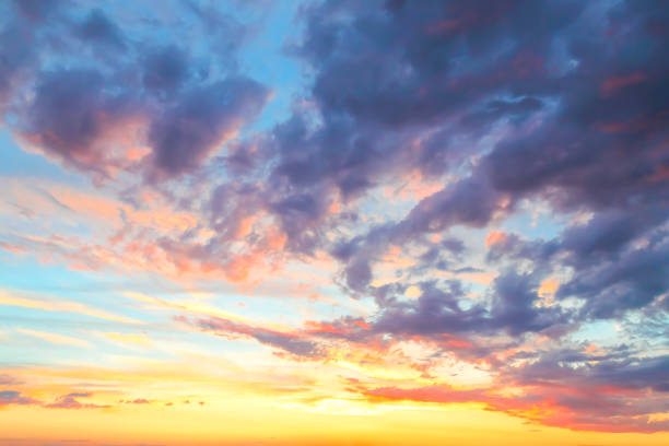 istock Heavenly summer background. Beautiful bright majestic dramatic evening sky at sunset or sunrise orange and blue with rays. The sun shines over the horizon against the backdrop of thunder clouds 1165257790