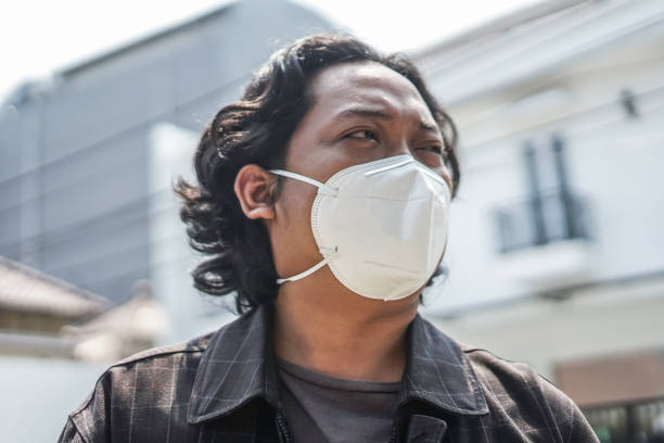 istock a man wears a white mouth mask 1165258019