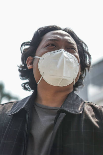 istock a man wears a white mouth mask 1165258055