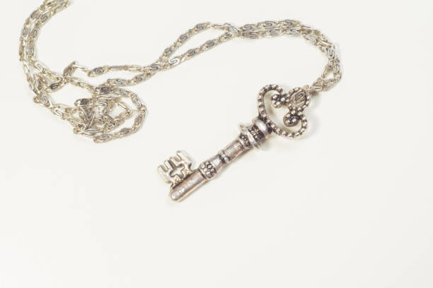 istock Vintage key with the chain isolated on white background. safety concept 1165260244
