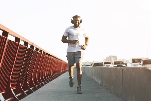 istock Smiling african american man running along the bridge 1165262432