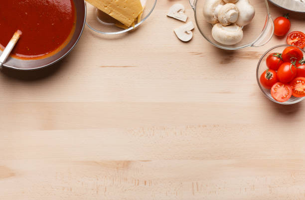 Pizza cooking ingredients. Frame of sauce, mushrooms and tomatoes with copy space, top view