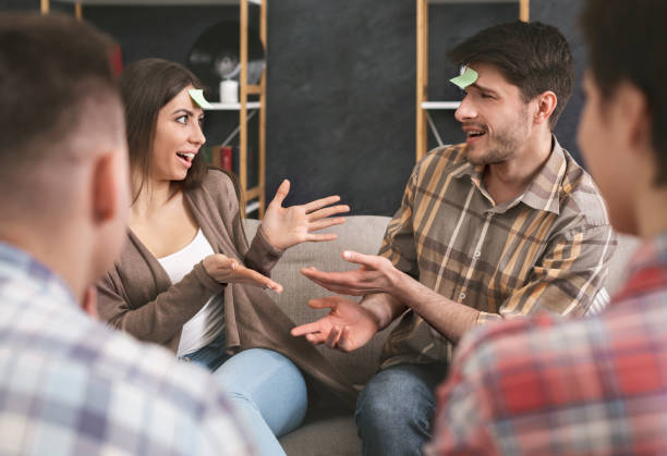 istock Engrossed couple playing forehead detective game with friends 1165263550