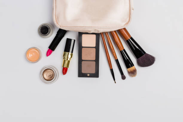istock Makeup products with cosmetic bag and macaroons on light background 1165263828