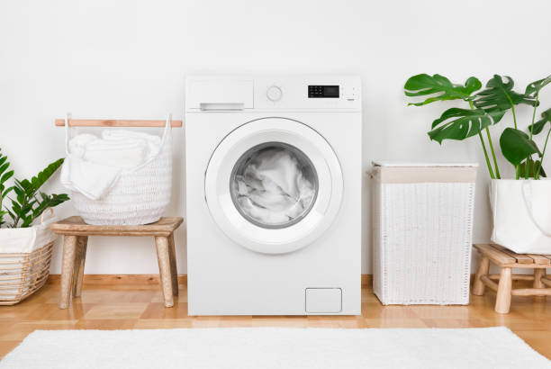 istock Modern washing machine, laundry in baskets and domestic room interior 1165264479