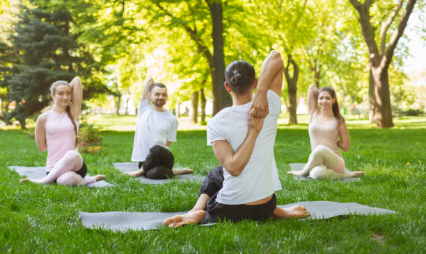 istock Group of people practicing yoga, sitting in Cow Face exercise 1165264501