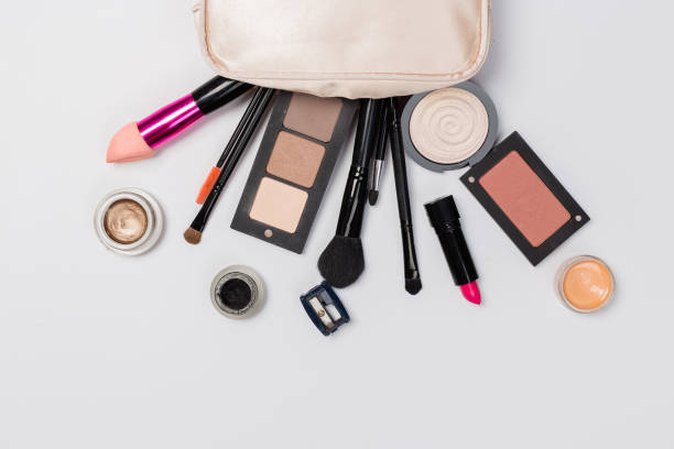 istock Makeup products with cosmetic bag and macaroons on light background 1165264631