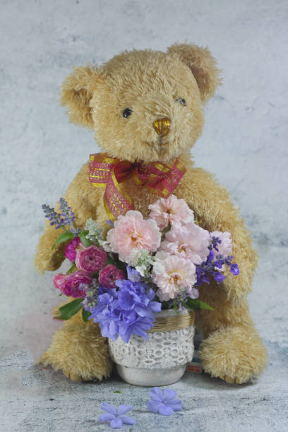 istock Teddy bear foll with flower bouquet. 1165264931