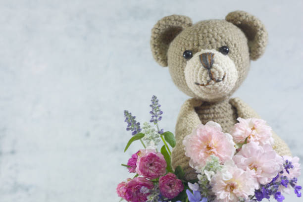istock Teddy bear foll with flower bouquet. 1165265008