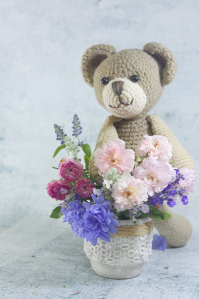 istock Teddy bear foll with flower bouquet. 1165265009