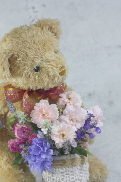 istock Teddy bear foll with flower bouquet. 1165265010