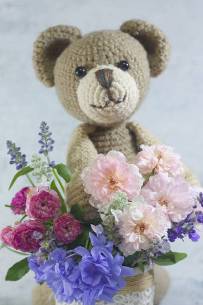 istock Teddy bear foll with flower bouquet. 1165265191