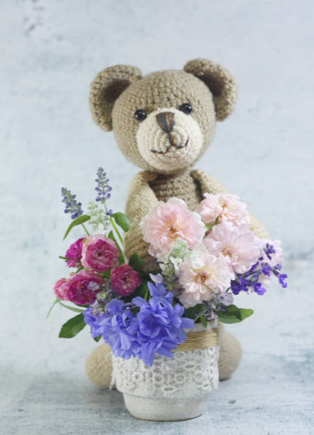 istock Teddy bear foll with flower bouquet. 1165265196