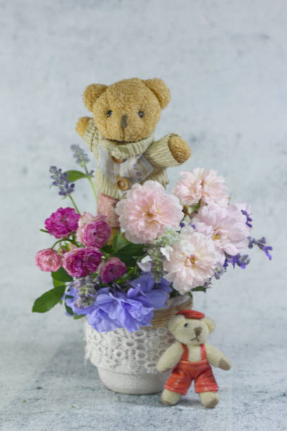 istock Teddy bear foll with flower bouquet. 1165265202