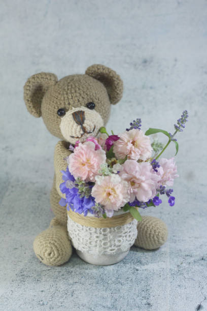 istock Teddy bear foll with flower bouquet. 1165265210