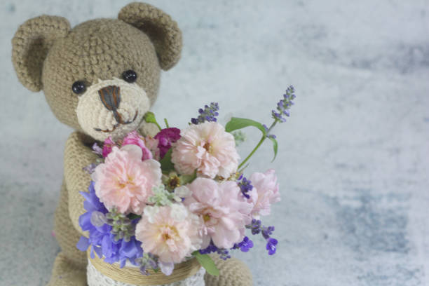 istock Teddy bear foll with flower bouquet. 1165265218