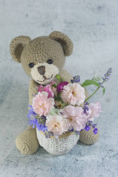 istock Teddy bear foll with flower bouquet. 1165265292