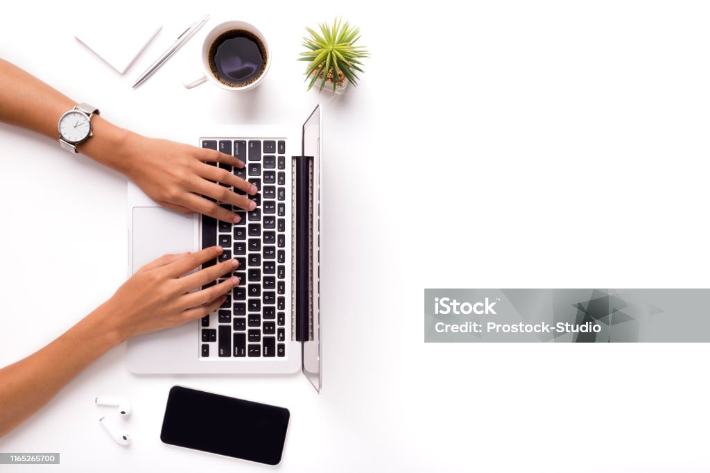 Woman typing on laptop on clean white office table with plant Woman typing on laptop on clean white office table with plant and cup of coffee, copy space Laptop Stock Photo