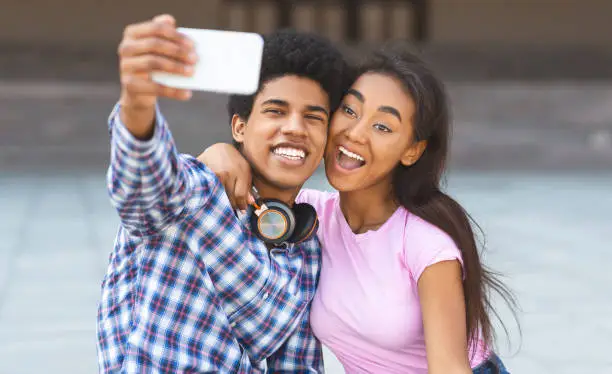 Photo of Teenagers taking selfie having fun and grimacing