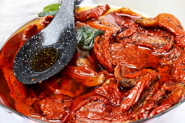 黒いスプーンで白いボウルにオリーブオイルを入れたトマトの日焼け - rosemary herb isolated ingredient ストックフォトと画像