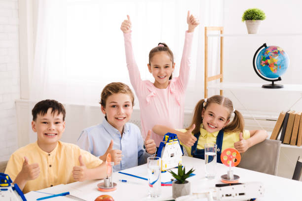 istock STEM lesson. Cheerful schoolchildren showing thumbs up 1165273994