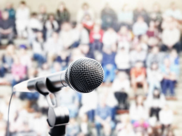 istock Microphone in front of defocused audience in bleachers 1165277668